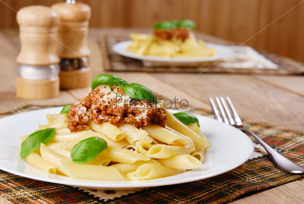 Rigatoni pasta with a tomato bolognese beef sauce in the white plate