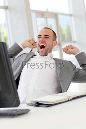 Portrait of relaxed salesman yawning in office