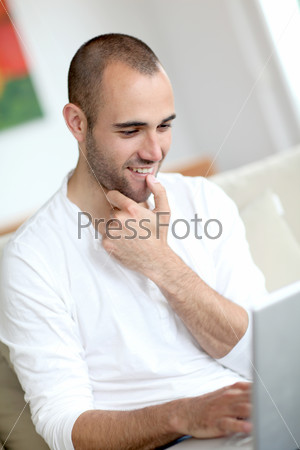 Closeup of handsome man websurfing on laptop computer