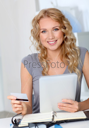 Beautiful woman doing online shopping in office