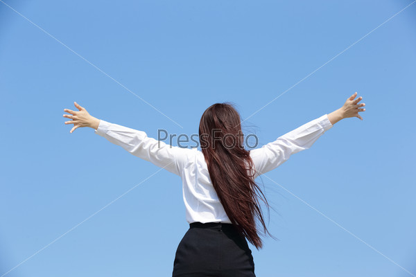 carefree business woman arms up and feel free isolated on blue sky background, asian beauty