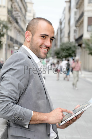 Man with suit jacket using touch pad in town