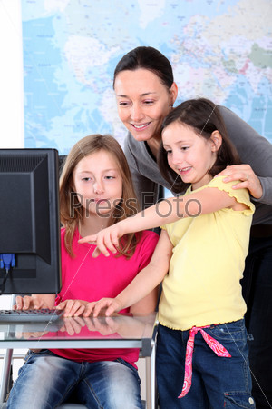 Teacher with kids in front of desktop computer