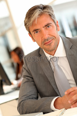 Handsome executive sitting at desk in office