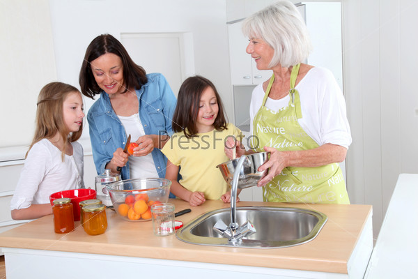 Portrait of grandmother, mother and kids in kitchen