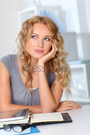 Portrait of beautiful blond woman in office with hand on chin