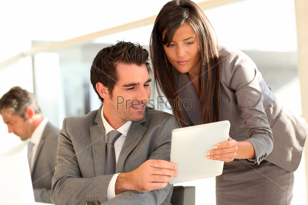 Business team using electronic tablet at work