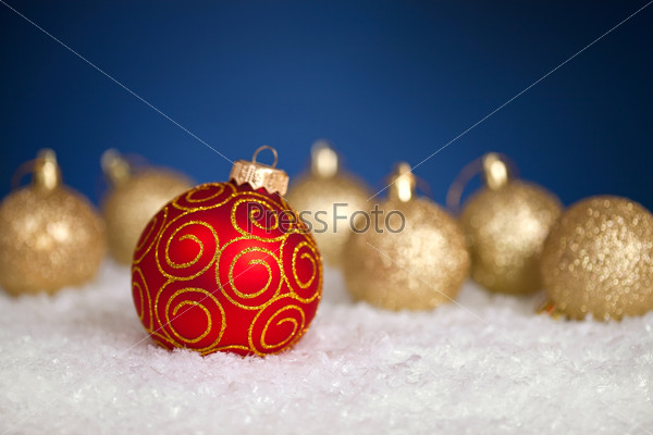Christmas balls in snow on blue background. \