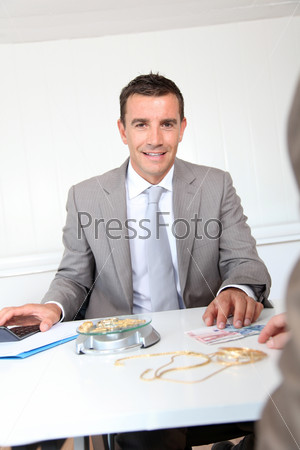 Businessman paying for golden jewels