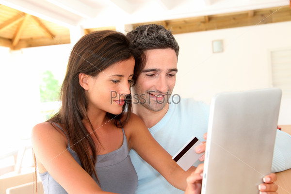 Couple at home doing online shopping with tablet