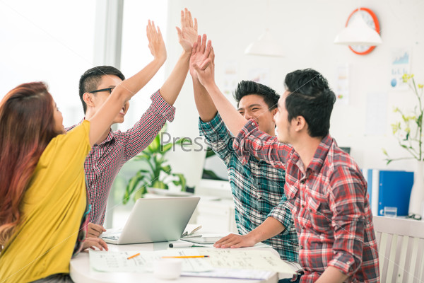 Young enthusiastic business team giving high five