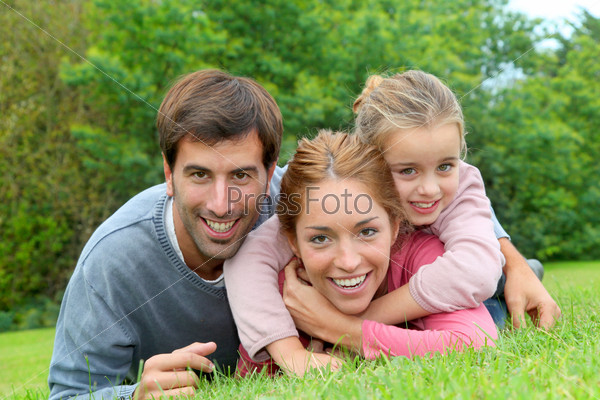 Portrait of cheerful family laying on grass