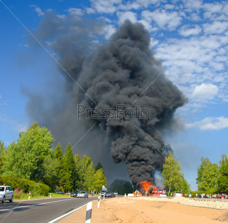 Truck in fire with black smoke on the road, stock photo