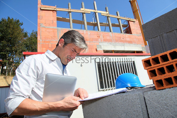 Entrepreneur checking plan on construction site