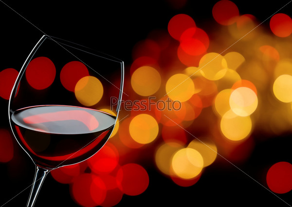 glass of red wine close up, background lights