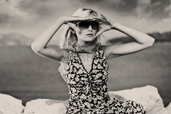 Young blonde wearing sunglasses on a sunny day , black white version
