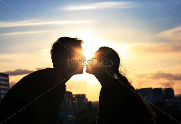 Kissing couple over evening city background