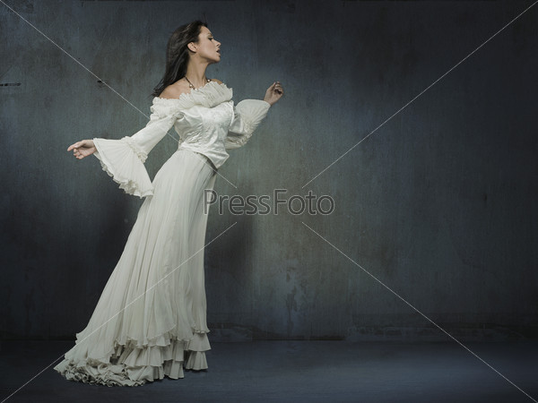 Beautiful woman wearing white dress over a grungy wall