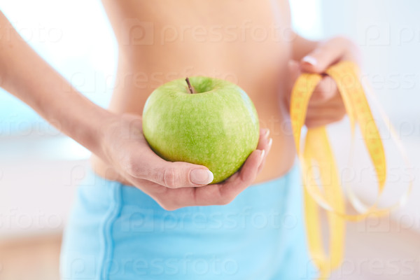 Hand of slim female with green apple