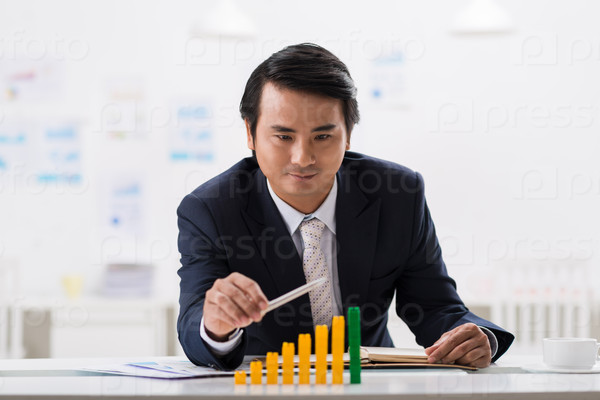 Satisfied businessman looking at ascending bar graph in front of him