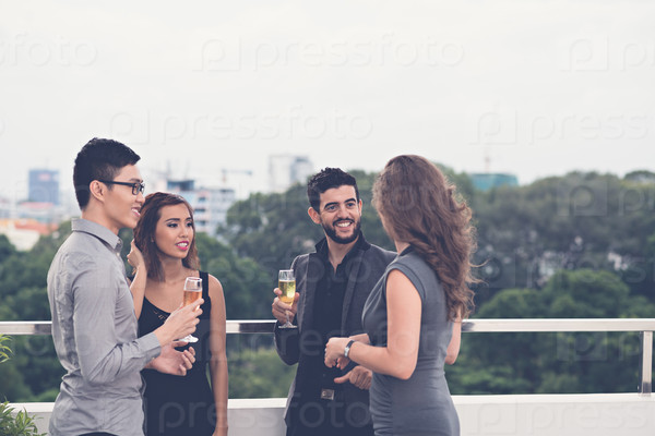 Young people drinking champagne and talking at the party
