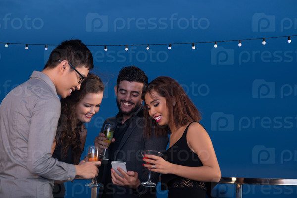 Man sharing photos on his smartphone with friends at the party