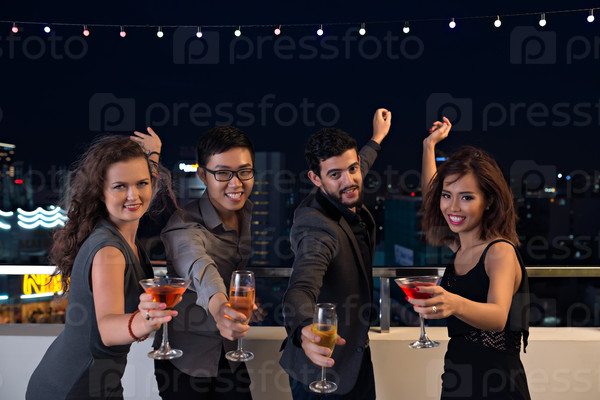 Group of young people with cocktails having fun at the party