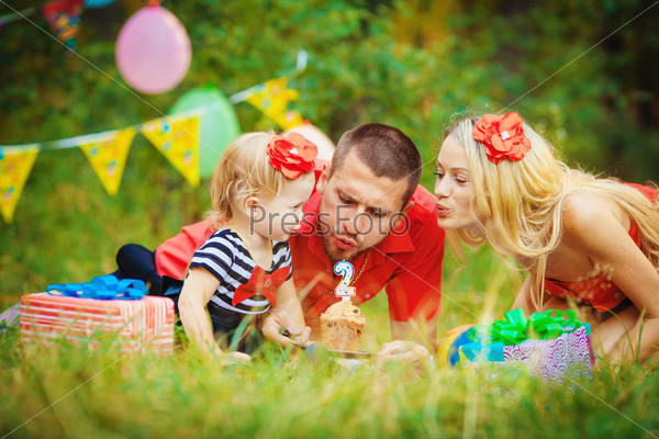 Family celebrating birthday party in green park outdoors