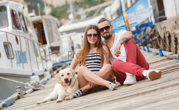 Couple with their dog. Pregnant woman with her husband and their dog golden retriever. Young Couple Walking with Dog by the sea. Happy family concept
