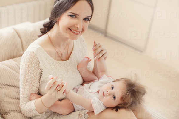 Portrait of a mother with her 4 months old baby at home. Happy child near to mum in her room. Portrait of a mother with her newborn baby.