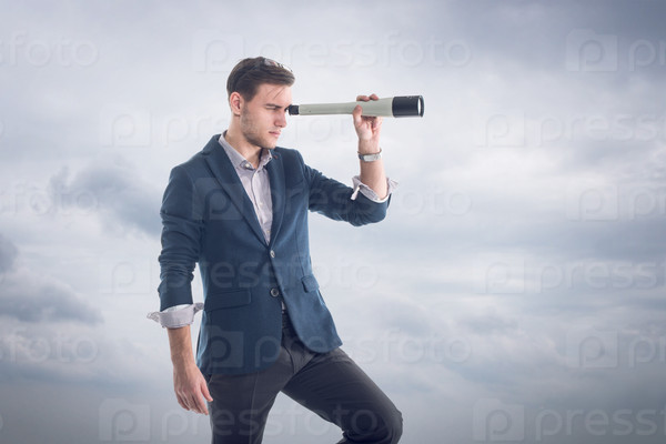 Young attractive handsome businessman standing  with clouds around and looking through the spyglass to find new perspectives