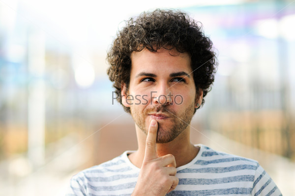Portrait of handsome man with curly hairstyle in urban background