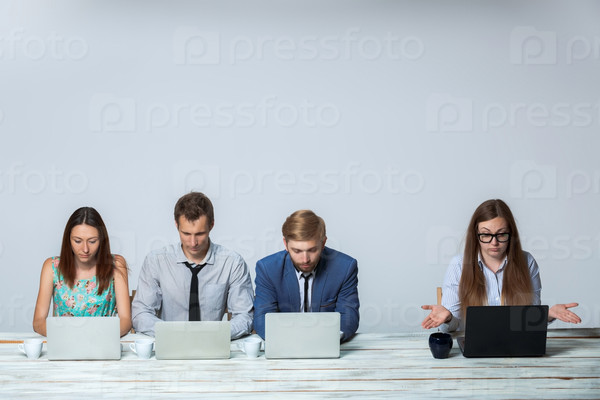 Business team working together at office on light gray background. all working on laptops. copyspace image
