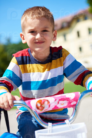 happy little boy have fun in park and learning to ride his first bike