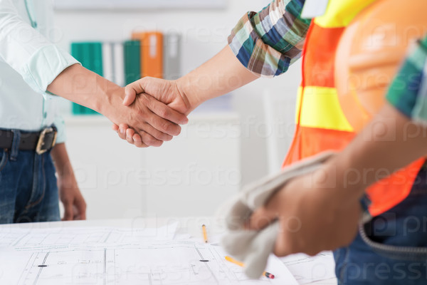 Cropped image of engineer and investor shaking hands after successful deal