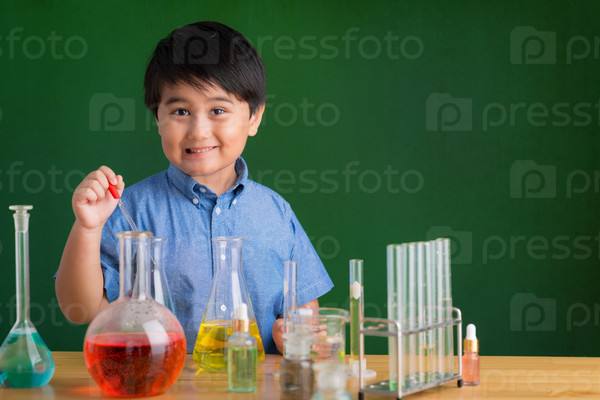 Cute boy carrying out an experiment in the science class
