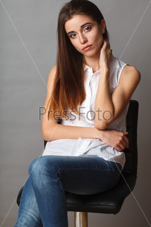 beautiful brunette fashion model posing at studio, sitting on chair, closeup portrait