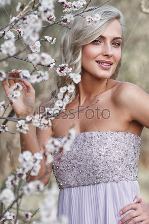 beautiful blonde woman portrait in a flowered spring garden