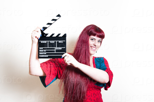 Young woman smiling showing movie clapper board on white background