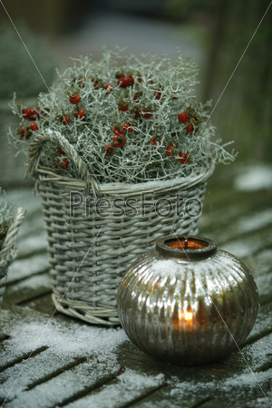Christmas decorations: plant in wicker basket and a candle