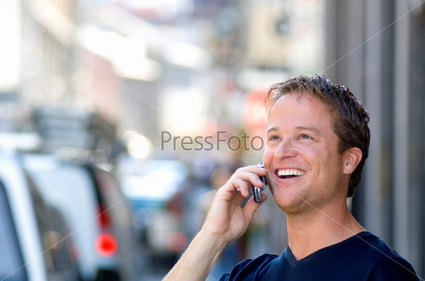 Portrait of a young man talking on mobile phone and laughing