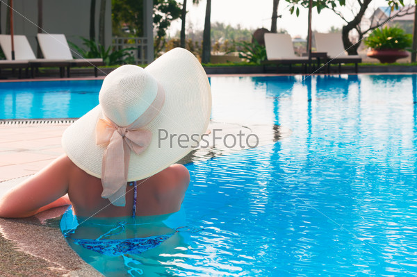 Woman  with  white hat  from back in swimming  pool