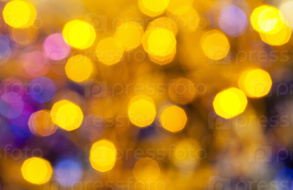abstract blurred background - yellow and blue shimmering Christmas lights bokeh of electric garlands on Xmas tree