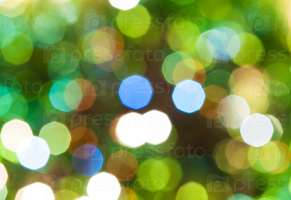 abstract blurred background - green shimmering Christmas lights of electric garlands on Xmas tree