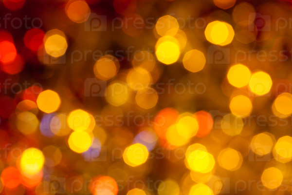 abstract blurred background - dark brown, yellow and red twinkling Christmas lights of electric garlands on Xmas tree