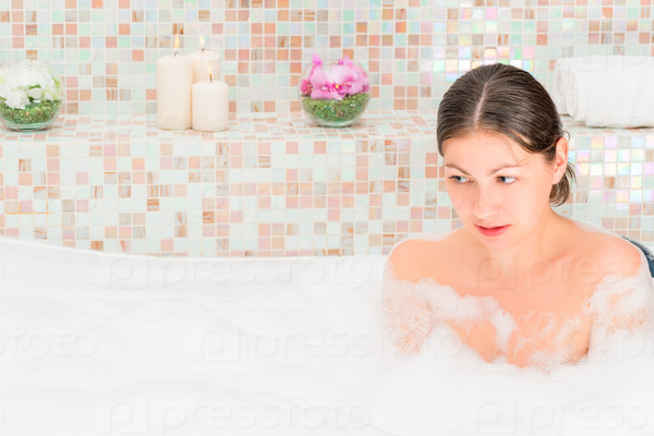 Brunette relaxing in the bath with foam