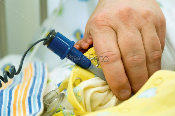 Hand of a neonatal nurse using a baby thermometer