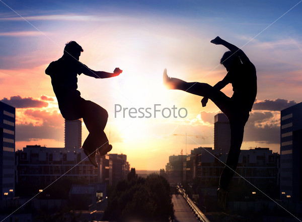 Two capoeira fighters over night city background