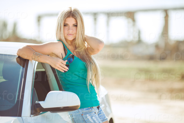happy young woman in car smiling enjoying car road trip\
travel vacation Driving sexy lady driver with long blond healthy\
hair in automobile spring - summer portrait