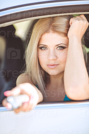 happy young woman in car smiling enjoying car road trip travel vacation. Driving. sexy lady driver with long blond healthy hair in automobile . spring - summer portrait